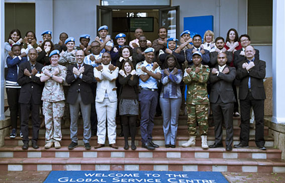 A group photo of women and men with their arms crossed as a symbol against rape. 