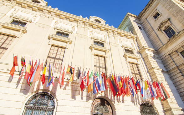 The facade of a building on which the national flags of the OSCE participating states are displayed.