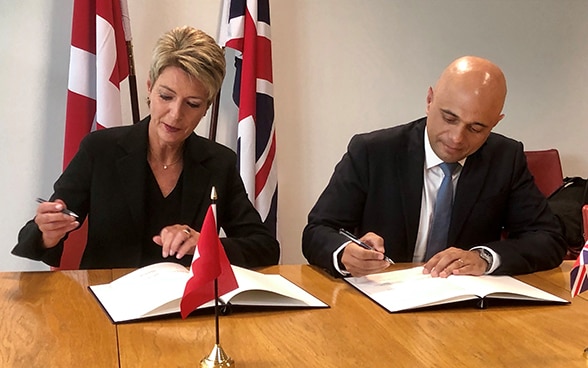 Bundesrätin Keller-Sutter und der britische Innenminister Javid unterschreiben eine Absichtserklärung sowie ein Abkommen in London.
