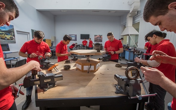 Jeunes apprentis travaillant ensemble sur un établi.