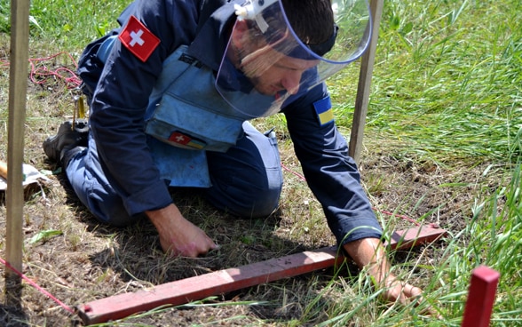 Un expert désamorce une mine en Ukraine, afin de réduire le danger auquel est exposée la population. 