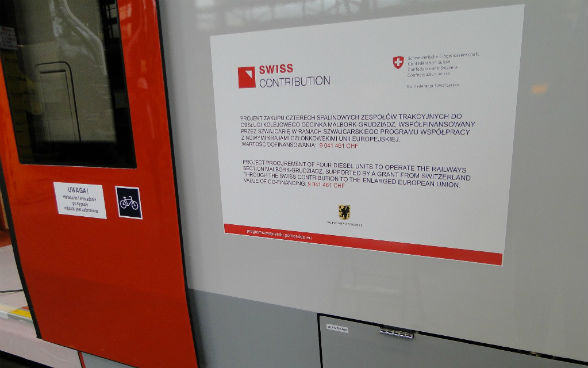 Billboard on the train informing about the Swiss Contribution