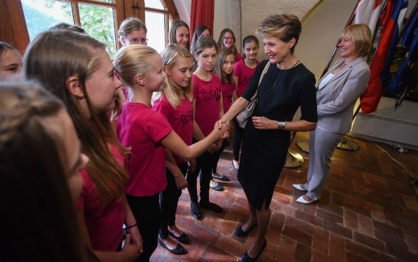 La présidente de la Confédération, Simonetta Sommaruga, en train de serrer la main d’enfants.