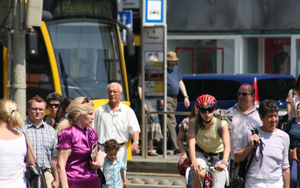 Menschen mit Tram im Hintergrund