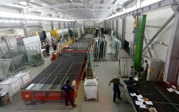 Des hommes travaillent dans l’atelier d’un fabricant de fenêtres.