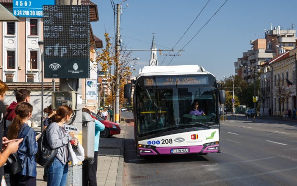 Deux élèves montent en courant les escaliers d’une école rénovée.