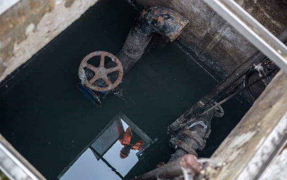 Bauarbeiter spiegelt sich im Wasser einer alten Pumpstation.