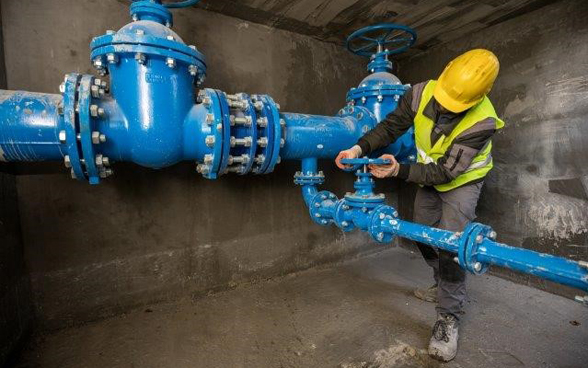 A worker checks that a large pipe is working.