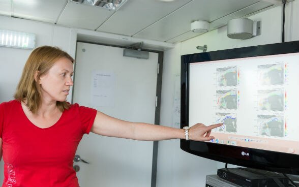 A researcher explains seawater measurement graphs on a computer.