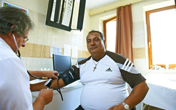 A doctor checks the blood pressure of a patient in a surgery.