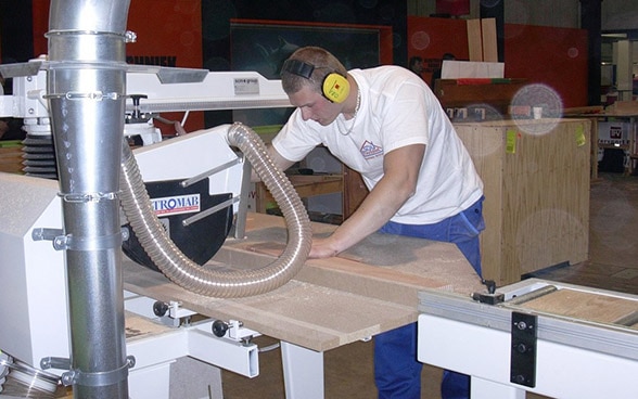 An apprentice operating a machin