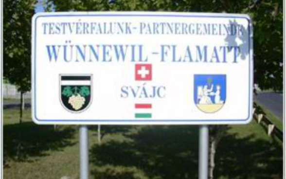 Place-name sign indicating Swiss-Hungarian partner communes.